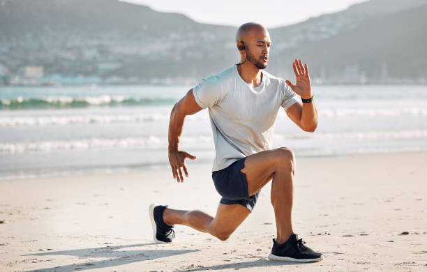 istock Shot of a young man doing lunges on the beach 1370421159