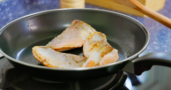 close up Salmon steak fry in pan - fish cooking in kitchen
