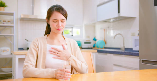 woman feel uncomfortable asian woman suffering from acid reflux or heartburn gastroesophageal reflux disease photos stock pictures, royalty-free photos & images