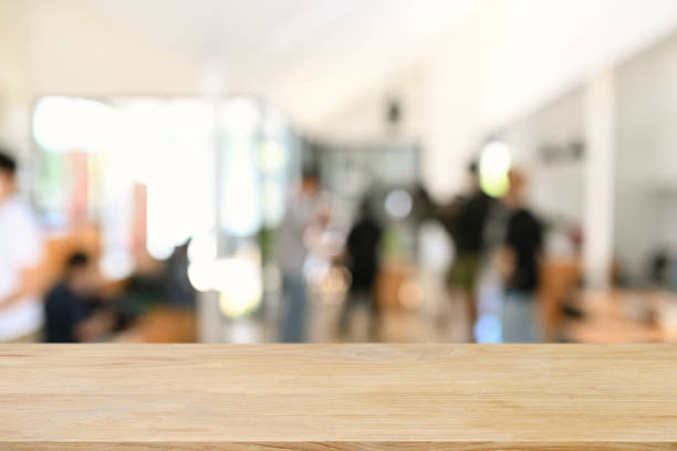 mesa de madeira vazia com empresários borrados na sala de reunião. copie espaço para exibição do produto. - pessoas ao fundo - fotografias e filmes do acervo