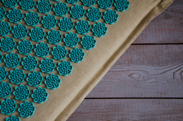 Massage on the mat. Close-up Massage mat on a wooden background. Close-up acupuncture mat stock pictures, royalty-free photos & images