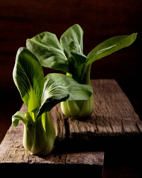 Bok choy or Chinese-cabbage with water drop on wooden board and wooden floor.