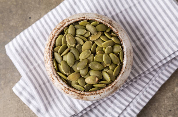 istock Pumpkin seeds in a bowl, superfoods. Copy space 1370430659