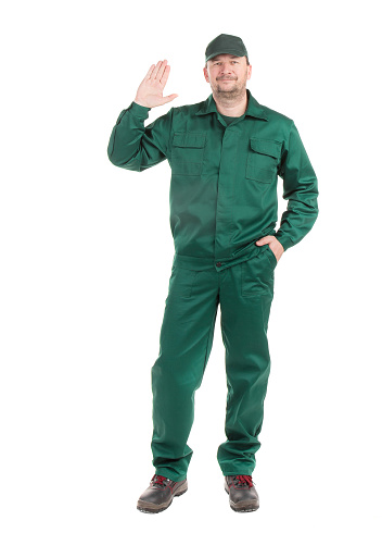 A worker in a green uniform raised his hand in salute. Isolated on a white background. Close-up.