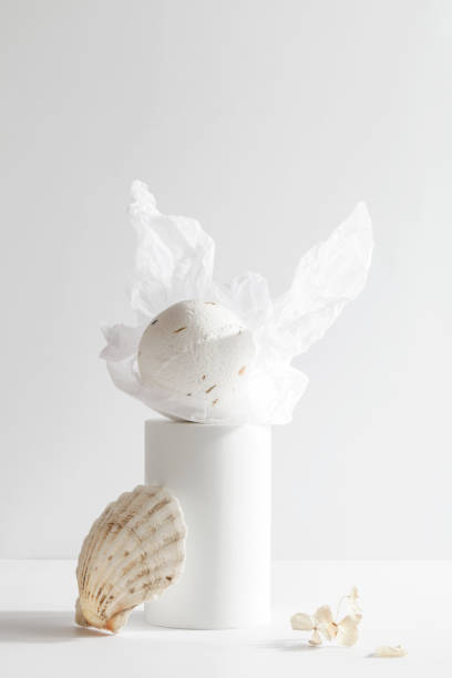 istock bath bomb on podium with seashell on white background. Still life for wall decoration in resort spa or salon. Spa, relax, wellness concept. 1370433036