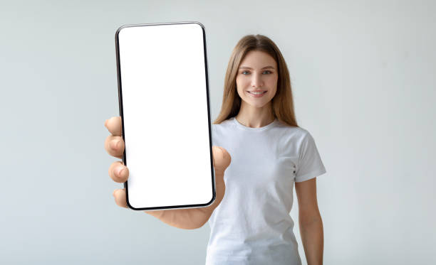 istock Lady holding mobile phone with empty screen in her hand 1370433041