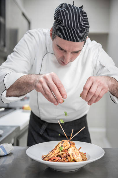 istock Chef prepares a meal in a  kitchen 1370435903