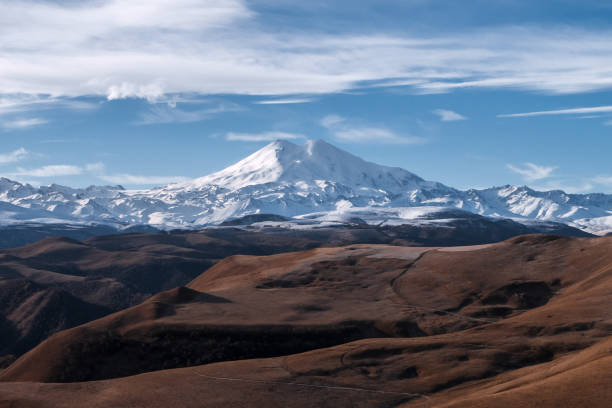 istock Great nature mountain range. Amazing perspective of  Elbrus with autumn fields, blue sky background. 1370436088