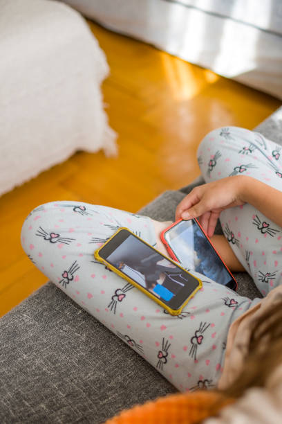 istock Little girl using mobile phone at home 1370436930