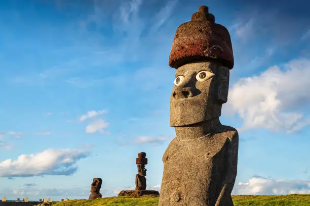 Easter Island Hanga Roa Ahu Ko Te Riku Moai Panorama. Ahu Ko Te Riku with restored eyes spotlit from warm sunset light at the Tahai Ceremonial Complex of the Hanga Road Coast under sunny summer skyscape. The Tahai Ceremonial Complex is an archaeological site on Rapa Nui in Chilean Polynesia. Restored in 1974. Hanga Roa, Rapa Nui National Park, Easter Island - Isla de Pascua, Chilenean Polynesia, Chile