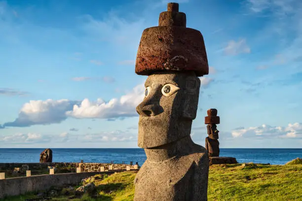 Easter Island Hanga Roa Ahu Ko Te Riku Moai Panorama Detail. Ahu Ko Te Riku with restored eyes - the only complete moai on Easter Island - spotlit from warm sunset light at the Tahai Ceremonial Complex of the Hanga Road Coast under sunny summer skyscape. The Tahai Ceremonial Complex is an archaeological site on Rapa Nui in Chilean Polynesia. Restored in 1974. Hanga Roa, Rapa Nui National Park, Easter Island - Isla de Pascua, Chilenean Polynesia, Chile