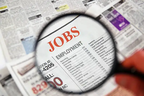 Photo of Job searching on newspaper using magnifier
