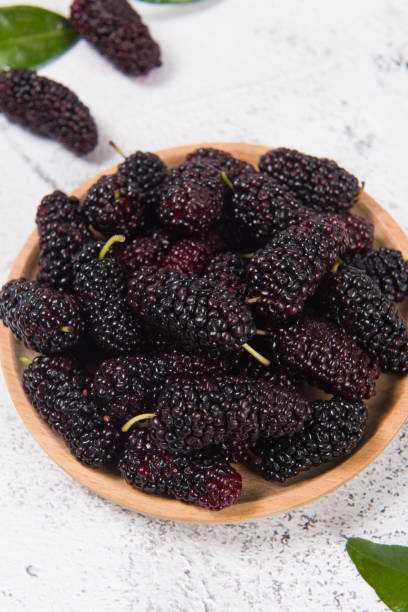 istock ripe mulberries fruit in wood plate on table 1370441239