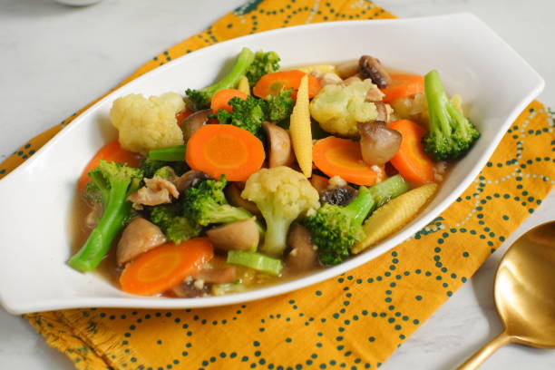 a plate of stir fry vegetables or cap cay in white background