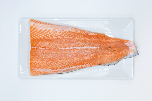 Salmon fish slice on white rectangle plate.