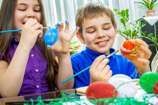 istock Mother and her children paint easter eggs 1370442894