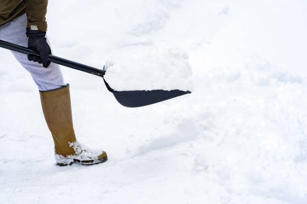 istock A person cleaning snow with snow plactic shovel 1370443696