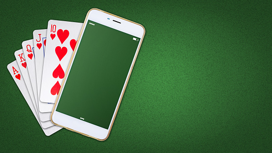 Playing cards and smartphone on a green background. Online poker concept.Online Casino. copy space. Top view. Gambling. Background.