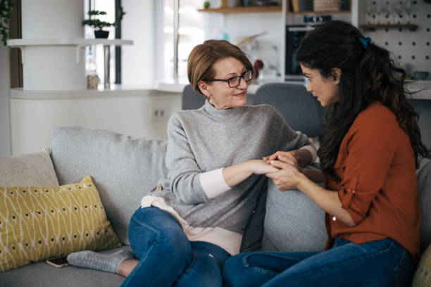 Mother and daughter talking to each other and holding hands stock photo