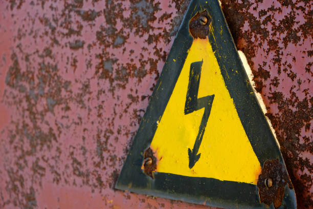 istock Old, rusty warning about danger and high voltage in form lightning yellow background. 1370448383