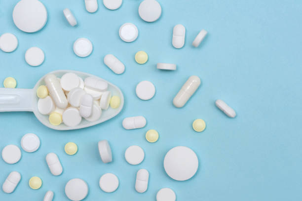 istock Various vitamins and nutritional supplements in a white spoon on a blue background. 1370448589