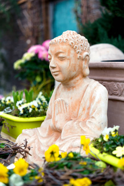 istock Buddha Sculpture and Potted Flowering Plants 1370452944