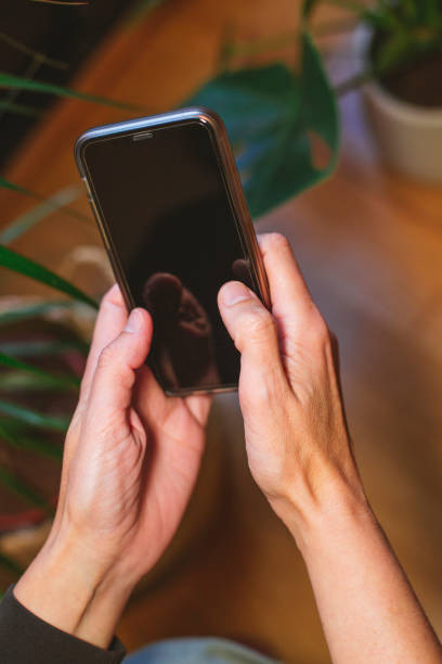 istock Woman's hands with a smartphone at home 1370453450