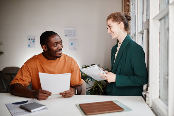 istock Two happy young economists planning work and discussing documents 1370454501
