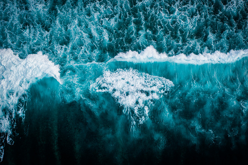 Powerful storm generated ocean swell exploding dangerously on the shoreline with soft golden sky