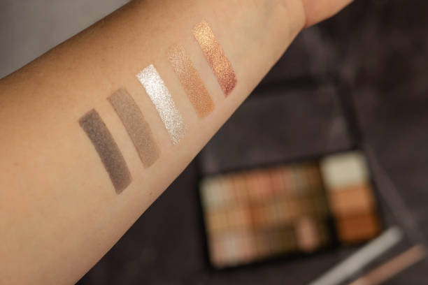 istock Eye shadow swatches on a hand against a marble dressing table with shadows and brushes. 1370456710