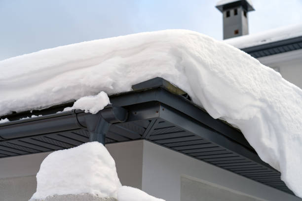 istock Metal Downpipe system, Guttering System, External downpipes and drainage pipes under snow. Corner of house with roof made of gray metal tiles and gutter covered with thick layer of snow in winter. 1370457074