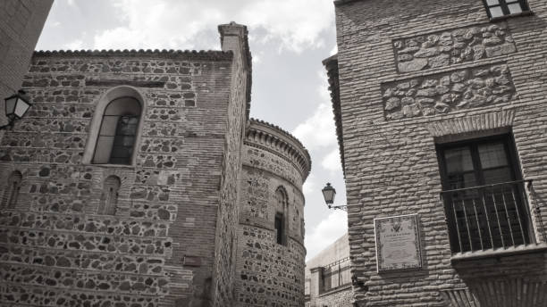 Augustinian Hermits Santa Ursula Convent, Toledo, Spain - July 19 2019 : The beautiful distinctive brickworks and the semi-circular curved wall of the convent bath in the hot sun in black and white.