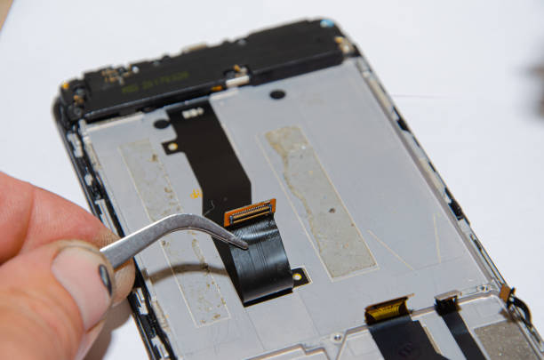 istock repairs the phone and examines small details with a magnifying glass 1370460265