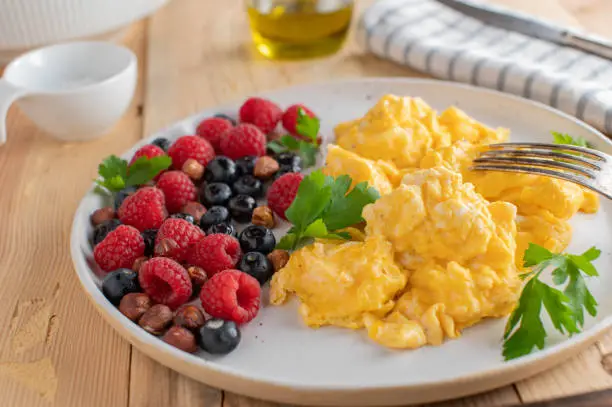 Homemade healthy low carb or ketogenic breakfast plate with scrambled eggs, fresh berries and nuts. High protein meal. Ready to eat