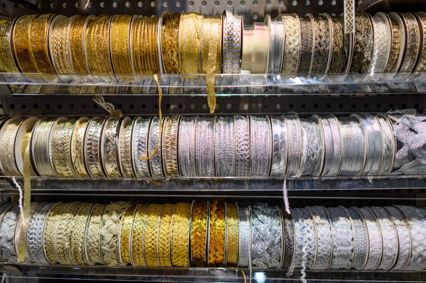 Gold and silver glitter ribbon roll on rack in craft shop. Artisan and Handicraft materials. DIY hobby concept