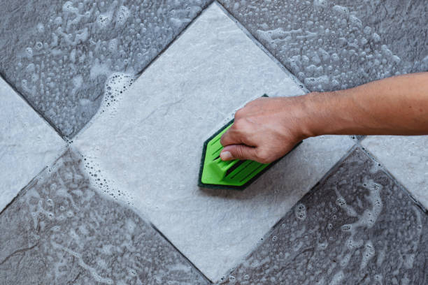 Cleaning the tiled floor with a plastic floor scrubber. stock photo