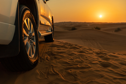 4x4 SUVs cars driving through the sand dunes in the desert of Abu Dhabi. Stock. Top view on SUVs in the desert.