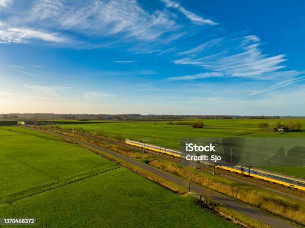 Train Of The Nederlandse Spoorwegen Driving Through A Rural Landscape During Springtime Stock Photo - Download Image Now