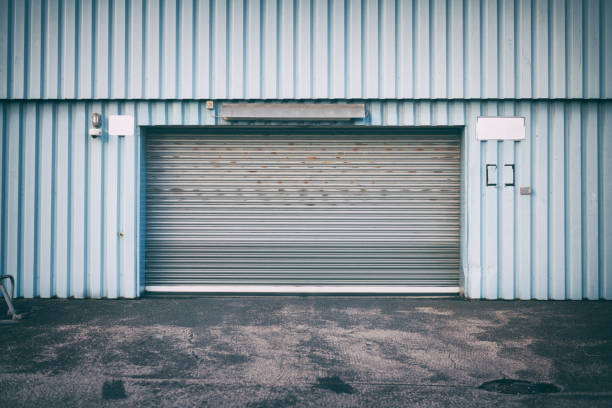 istock Rolling garage door and light blue warehouse wall 1370470929