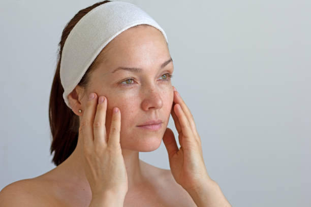 istock Middle aged woman without make up touching her face 1370472351