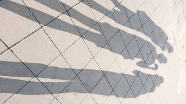 istock shadow of three people on footpath. 1370472844