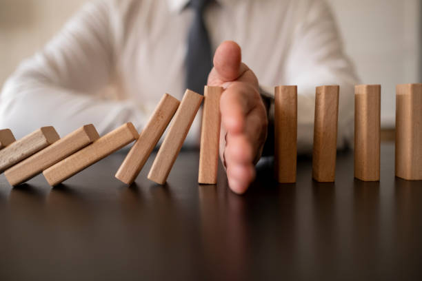 istock Businessman Stop Domino Effect. Risk Management and Insurance Concept 1370474795