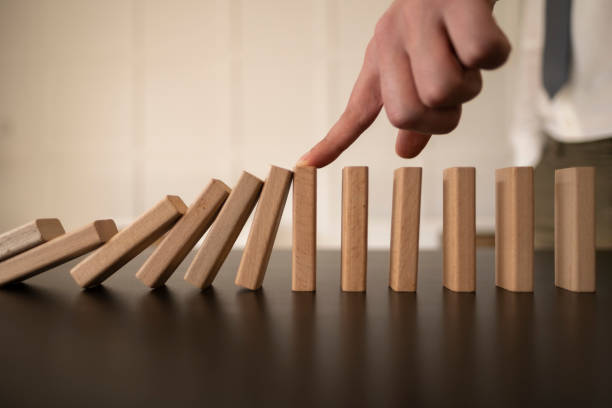 istock Businessman Stop Domino Effect. Risk Management and Insurance Concept 1370474796