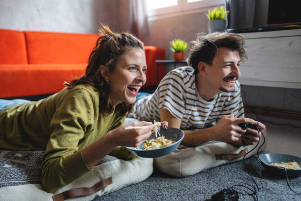 Young Cute Competitive Boyfriend Girlfriend Playing Video Games In Couch  Stock Photo, Picture and Royalty Free Image. Image 34313215.