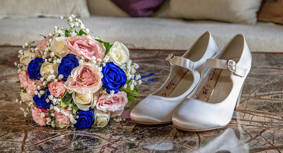Shoes and flowers on a table at a wedding.