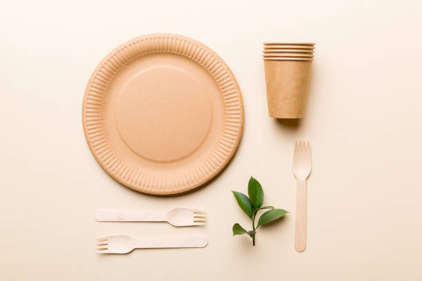istock set of empty reusable disposable eco-friendly plates, cups, utensils on light white colored table background. top view. Biodegradable craft dishes. Recycling concept. Close-up 1370476515