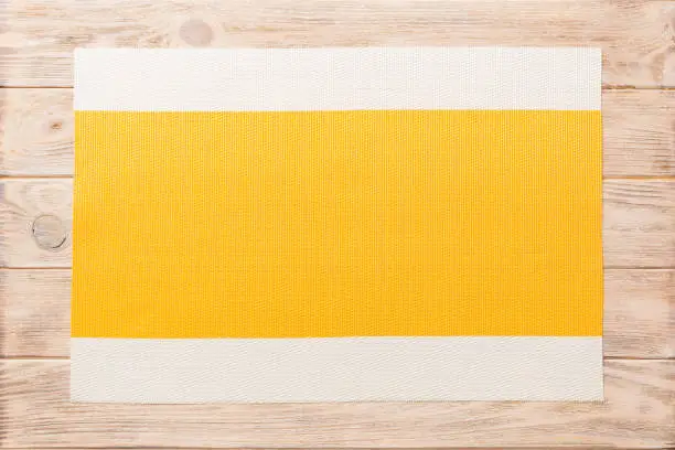Top view of yellow tablecloth for food on cement background. Empty space for your design.