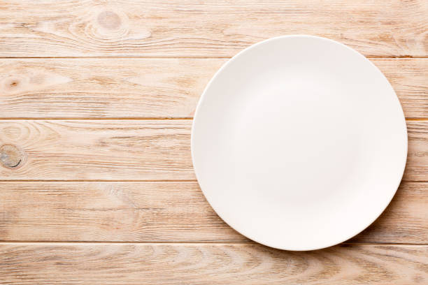istock Top view of empty light plate on wooden background. Empty space for your design 1370476541