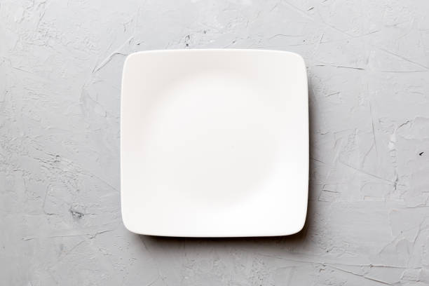 istock Top view of empty square plate on cement background. Empty space for your design 1370476574