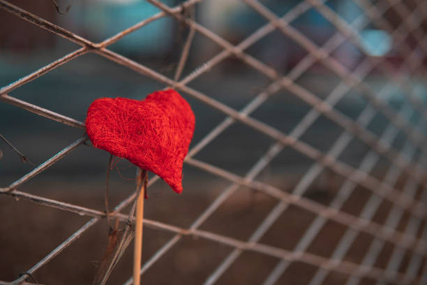 istock Red heart in a fence 1370479570